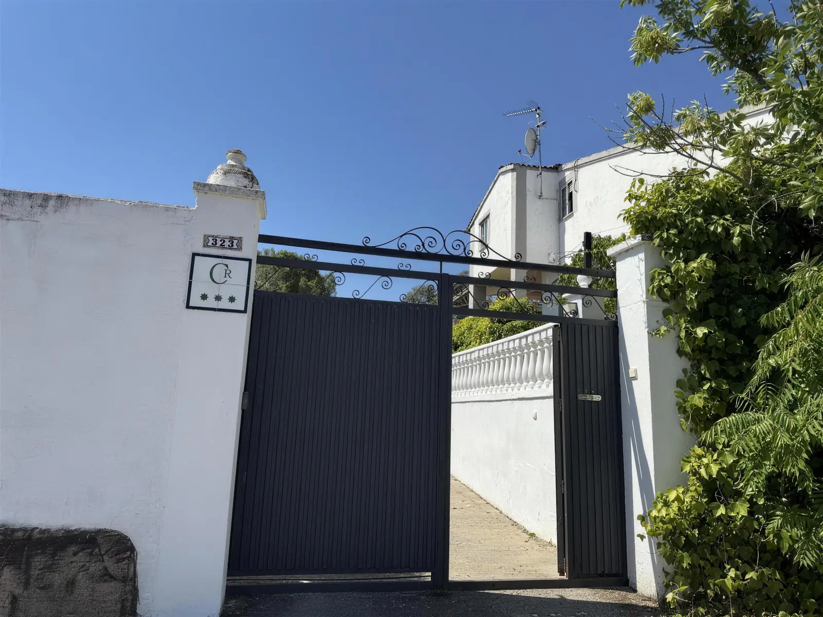 Portón de entrada de La Berruca con el azulejo de la casa