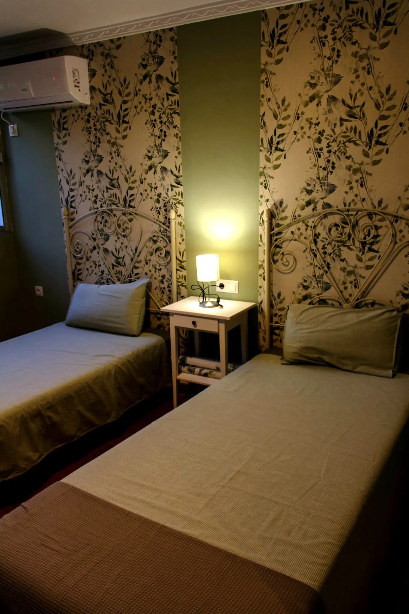 Dormitorio con dos camas individuales y papel pintado de flores