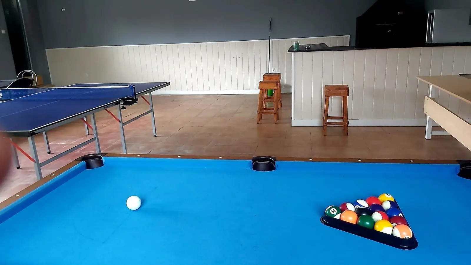 Mesa de billar con el ping-pong y la barra al fondo